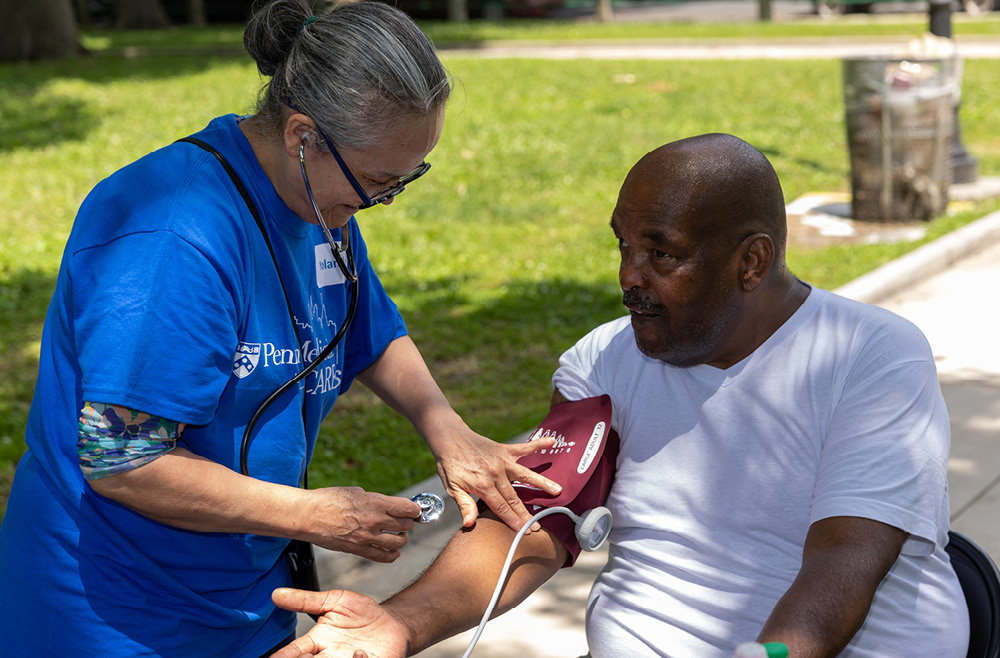 A community member gets his blood pressure checked